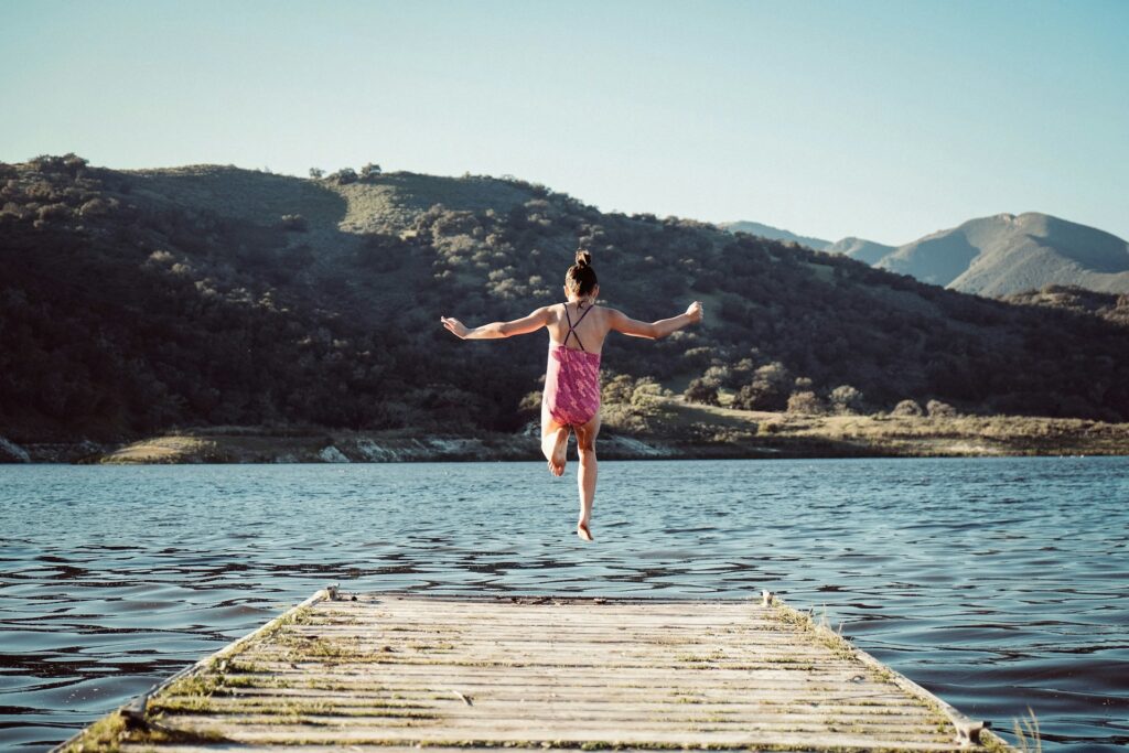Jeune fille qui saute dans un lac.